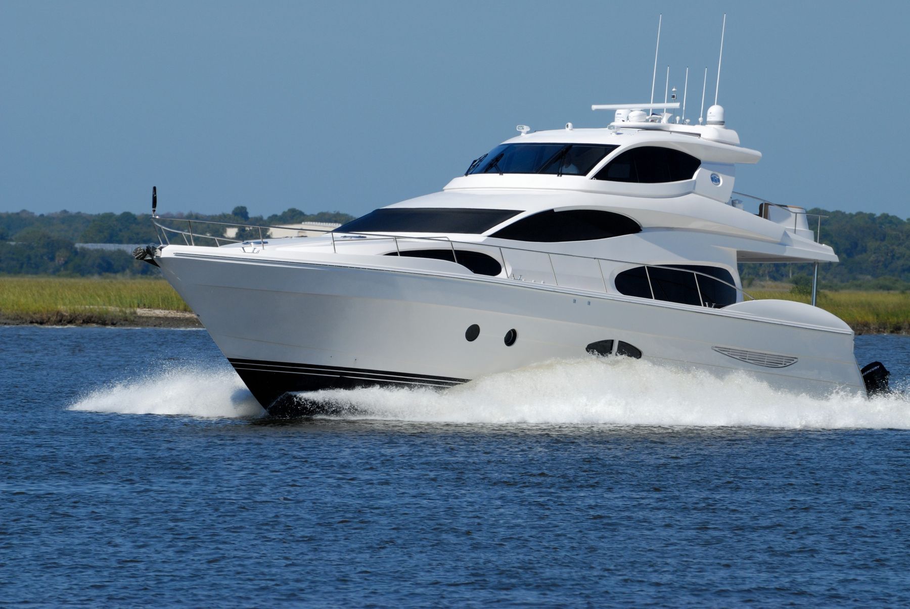 Large private yacht seen from the water at sunset